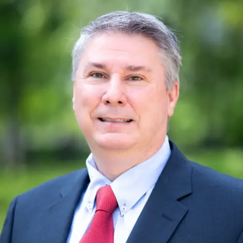 brian pendley wearing a suit and tie smiling into the camera