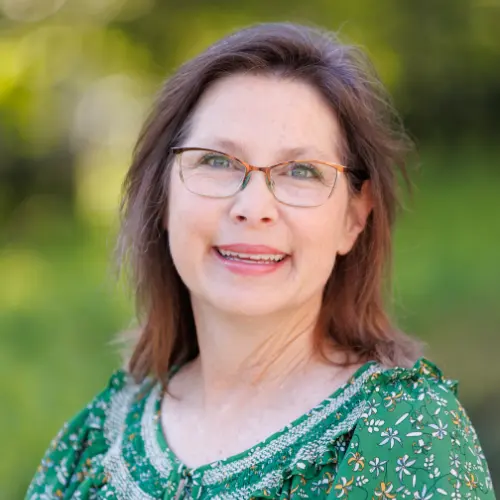 delana harbison wearing a green shirt smiling into the camera