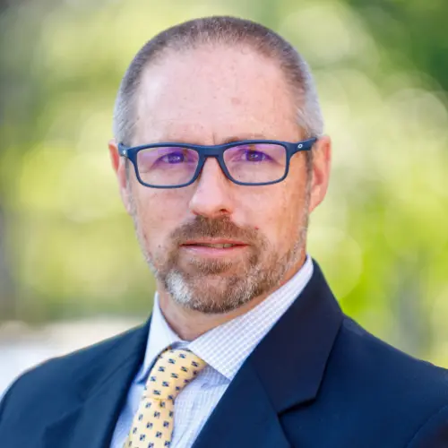 dr hunter christian wearing a suit and tie smiling into the camera