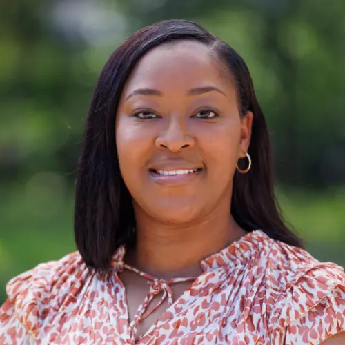 ronica fuller wearing a red and white floral top smiling into the camera